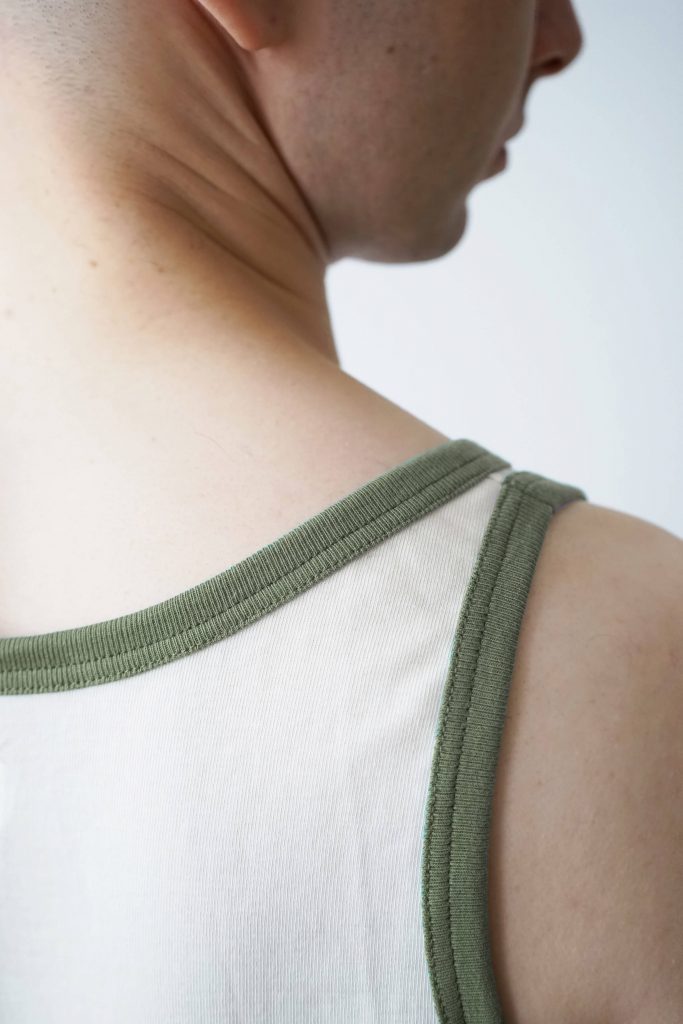 Ecru tank top with khaki rib binding made of heavy-weight organic cotton by REH (GERMANY). The enduring cotton top for men is made in Germany, from knitting, dying to sewing.